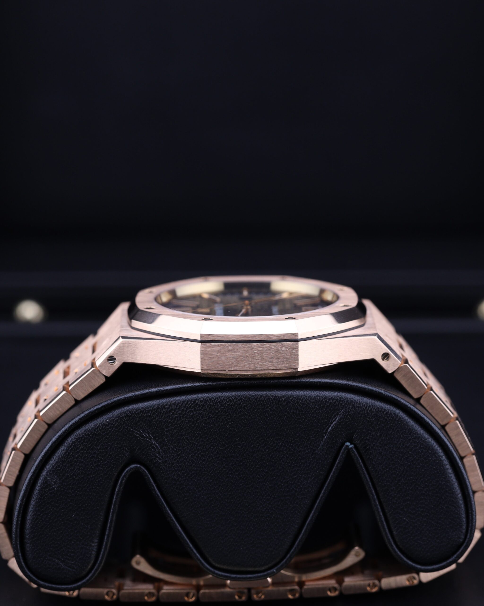 Side profile of rose gold watch with blue face